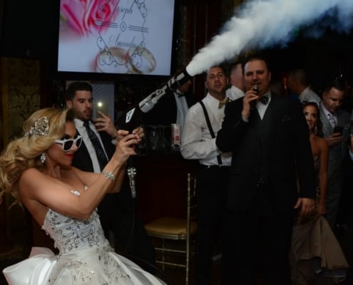 A Bride in White Shades Blowing Smoke on Crowd